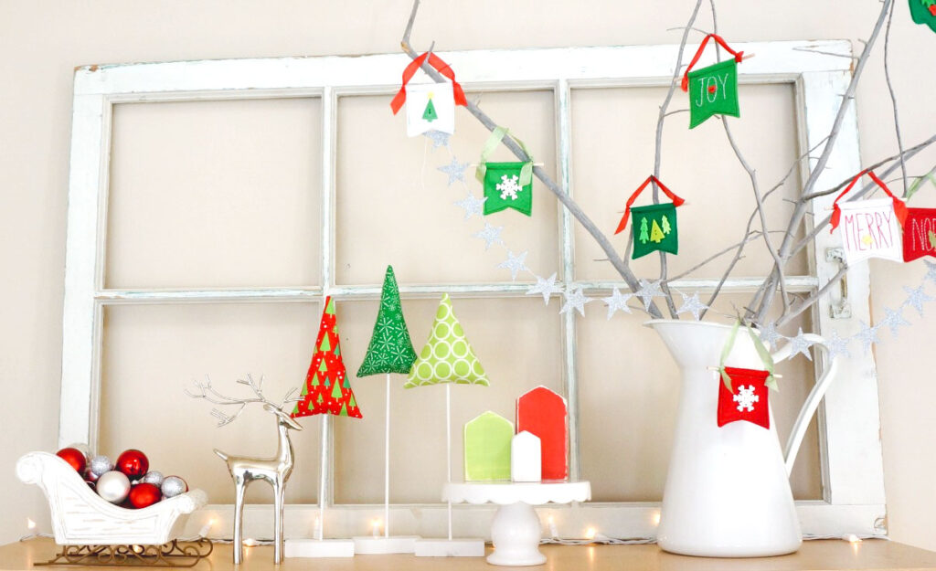 Fabric Tree tutorial by top US sewing blog Ameroonie Designs: IMage of holiday scene with window, fabric trees and houses.