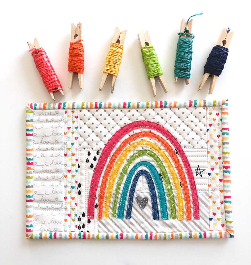Mini Rainbow Applique Pattern by top US sewing blog Ameroonie Designs image of: rainbow mug rug with embroidery floss skeins.