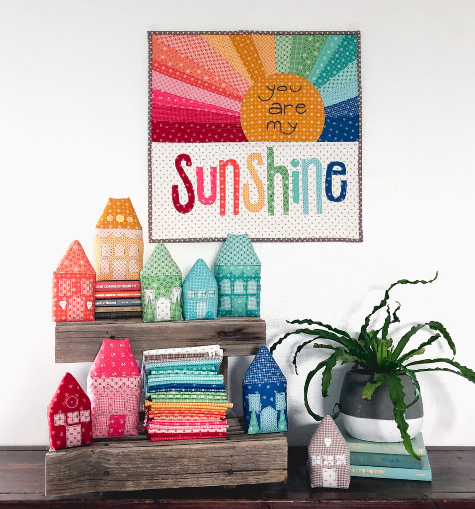 Rainbow Village with Prim fabric by Top US sewing blog Ameroonie Designs: image of Rainbow Sunshine mini quilt and fabric houses.