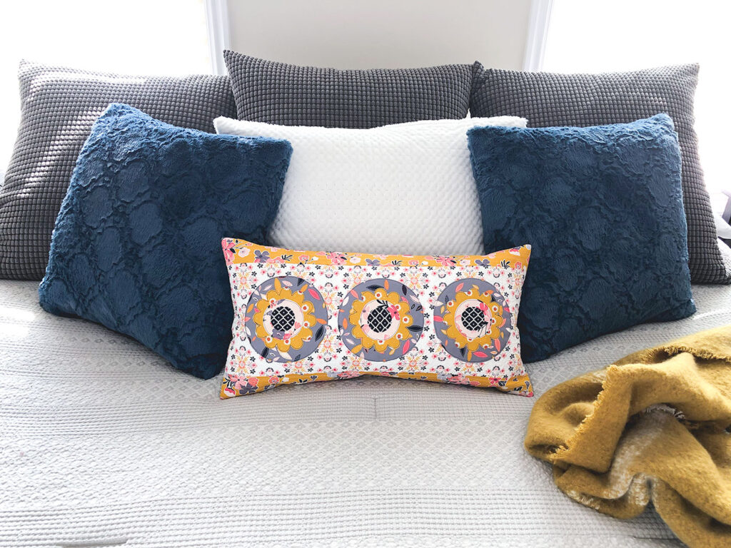 Simple and stunning raw-edge applique by Top US sewing blog Ameroonie Designs. Image of: lumbar pillow on bed.