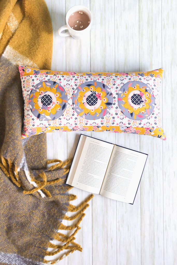 Simple and stunning raw-edge applique by Top US sewing blog Ameroonie Designs. Image of: lumbar pillow with book and hot cocoa