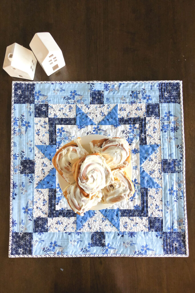 Easy table topper quilt by Top US sewing blog Ameroonie Designs. Image of: table topper with cinnamon rolls.