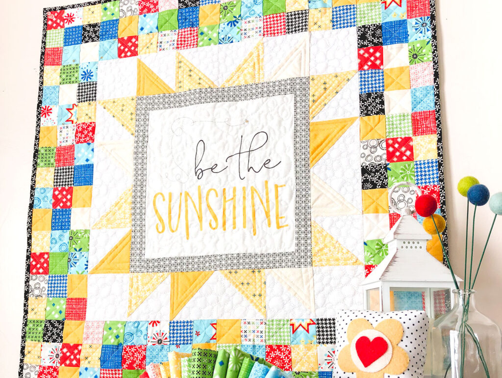 Sew a stunning mini quilt with a fabric panel by top US sewing blog Ameroonie Designs. Image of  close up of mini quilt to show quilting.