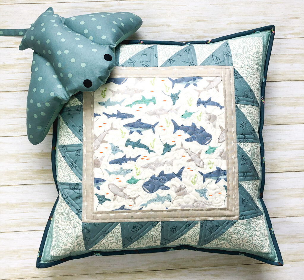 Shark teeth pillow by top US sewing blog Ameroonie Designs. Image of quilted pillow with Manta Shark stuffed pillow.