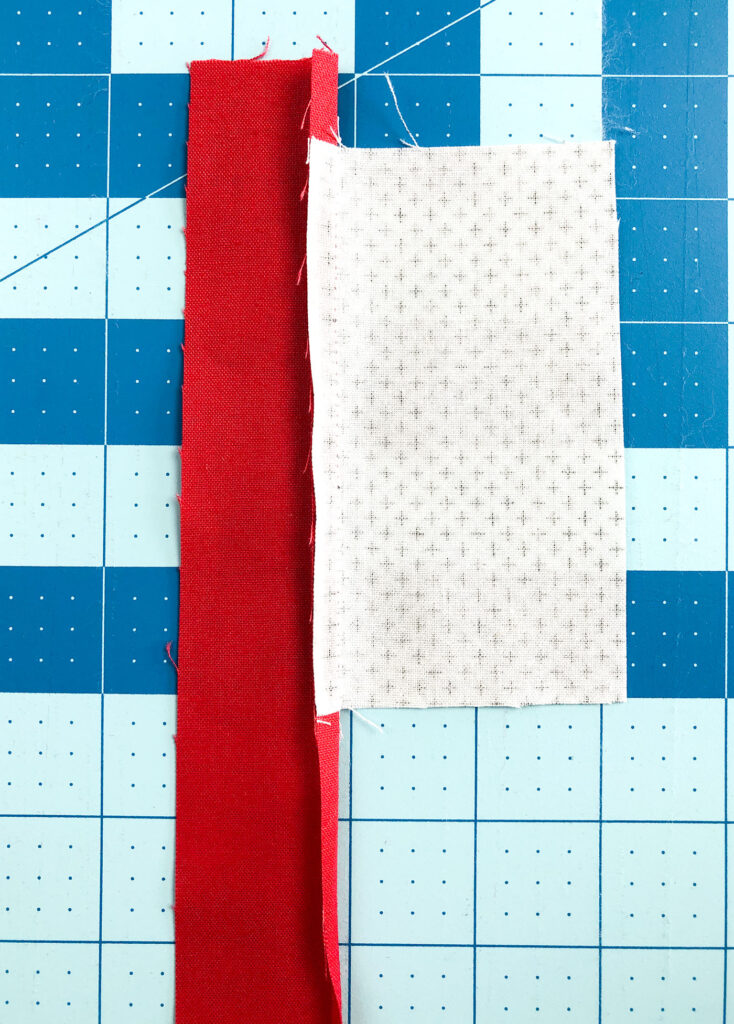 Wide Stripe Modern Rainbow mug rug tutorial by top US sewing blog Ameroonie Designs. Image of pressing seam allowance toward red strip.