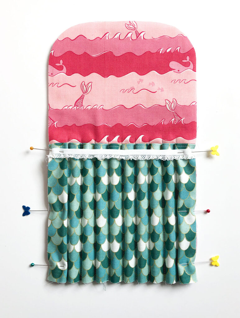 Sew a beautiful colored pencil pouch with top US sewing blog Ameroonie Designs. Image of pinning sides of pockets and elastic to inside of pouch.