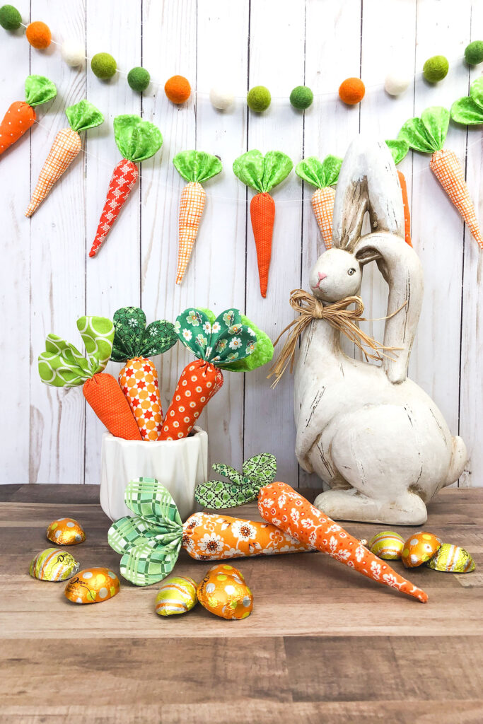 How to sew fabric carrots with top US sewing blog Ameroonie Designs. Image of cement bunny with fabric carrot garland and carrots in buckets.