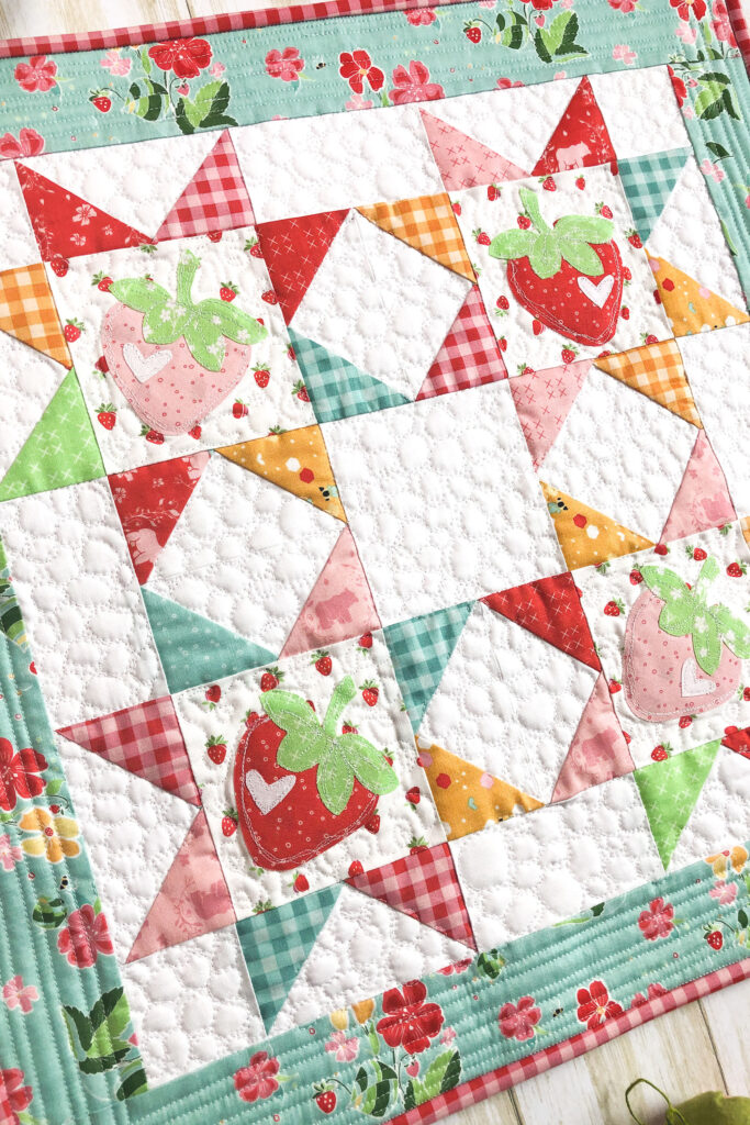 Strawberry Springtime mini quilt free pattern by top US sewing blog Ameroonie Designs. Image of close up of sawtooth star blocks in mini quilt.