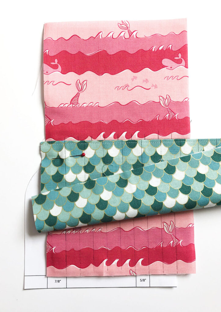 Sew a beautiful colored pencil pouch with top US sewing blog Ameroonie Designs. Image of lining up first pocket marks to create pencil pockets.