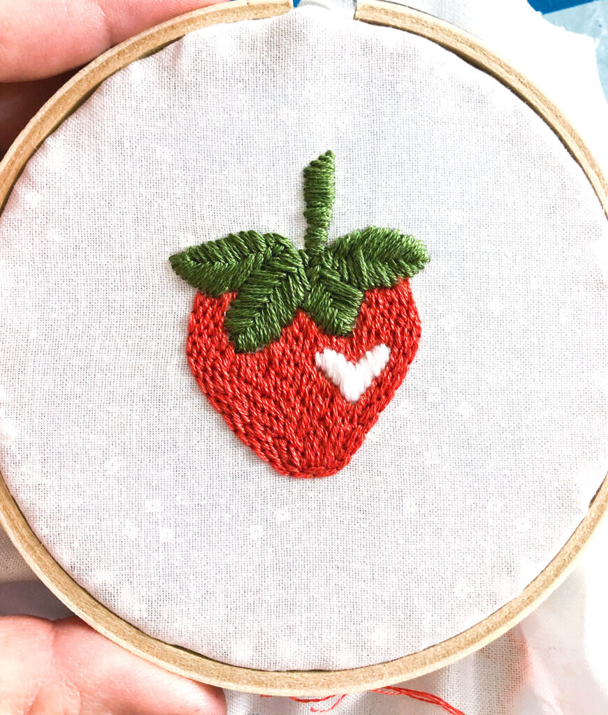 Learn how to stitch a layered back stitch. Image of strawberry embroidered with layered back stitch.