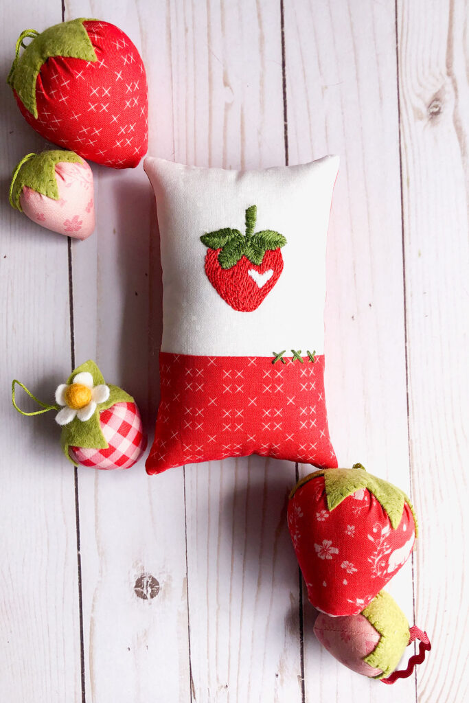 Learn how to stitch a layered back stitch. Image of mini pillow with embroidered strawberry.