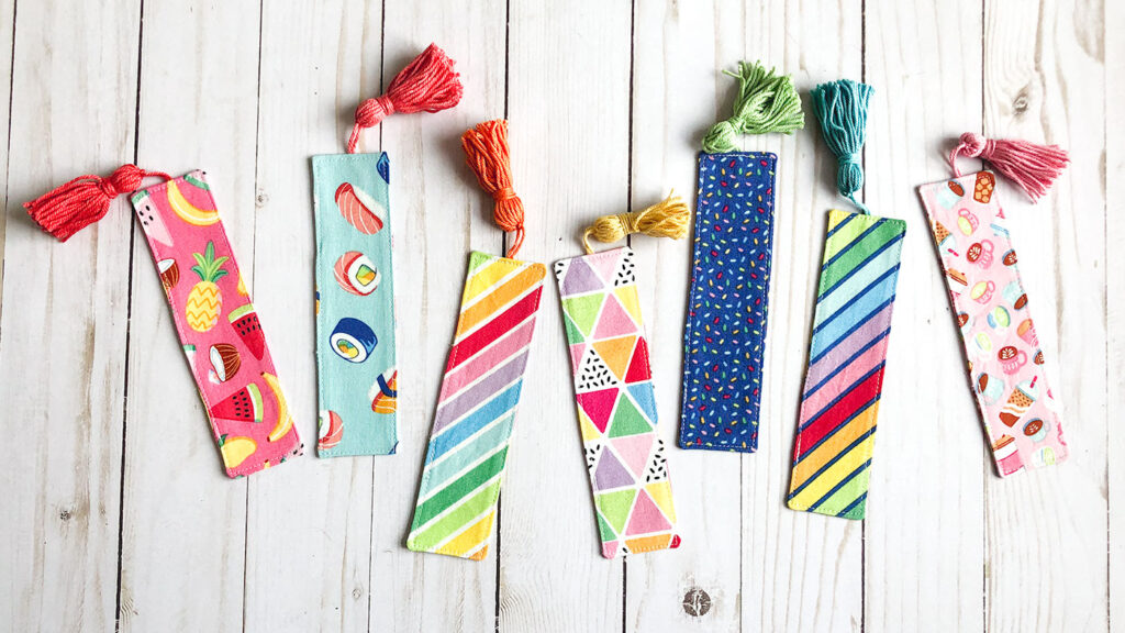 How to sew a fabric cover for a mini notebook with top US sewing blog Ameroonie Designs. Image of fabric bookmarks in rainbowfruit fabrics.