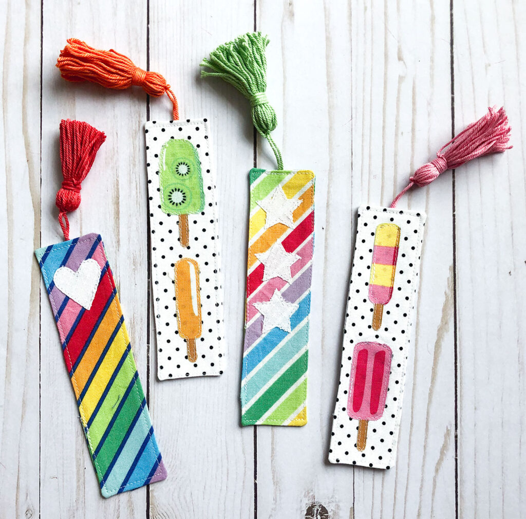 How to sew a tasseled fabric bookmark with top US sewing blog Ameroonie Designs. Image of brightly colored tasseled fabric bookmarks with applique.