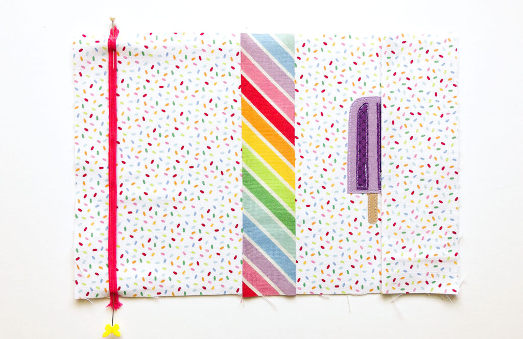 How to sew a fabric cover for a mini notebook with top US sewing blog Ameroonie Designs. Image of positioning elastic and sleeves on notebook cover.