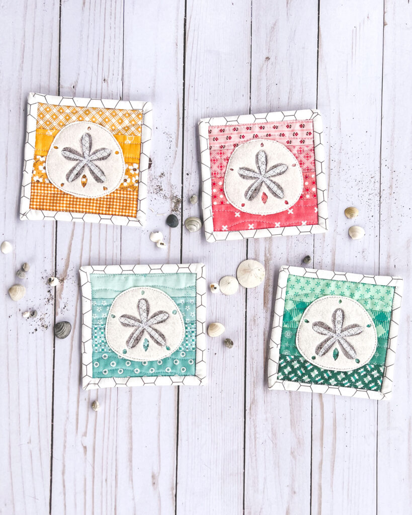 Free Sand Dollar Coaster sewing pattern by top US sewing blog Ameroonie Designs. Image of sand dollar coasters with shells and sand.
