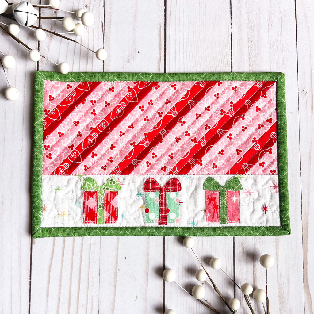 Five quick and easy tips for quilting small projects by Top US sewing blog Ameroonie Designs. Image of mug rug with Christmas gifts and striped patchwork.