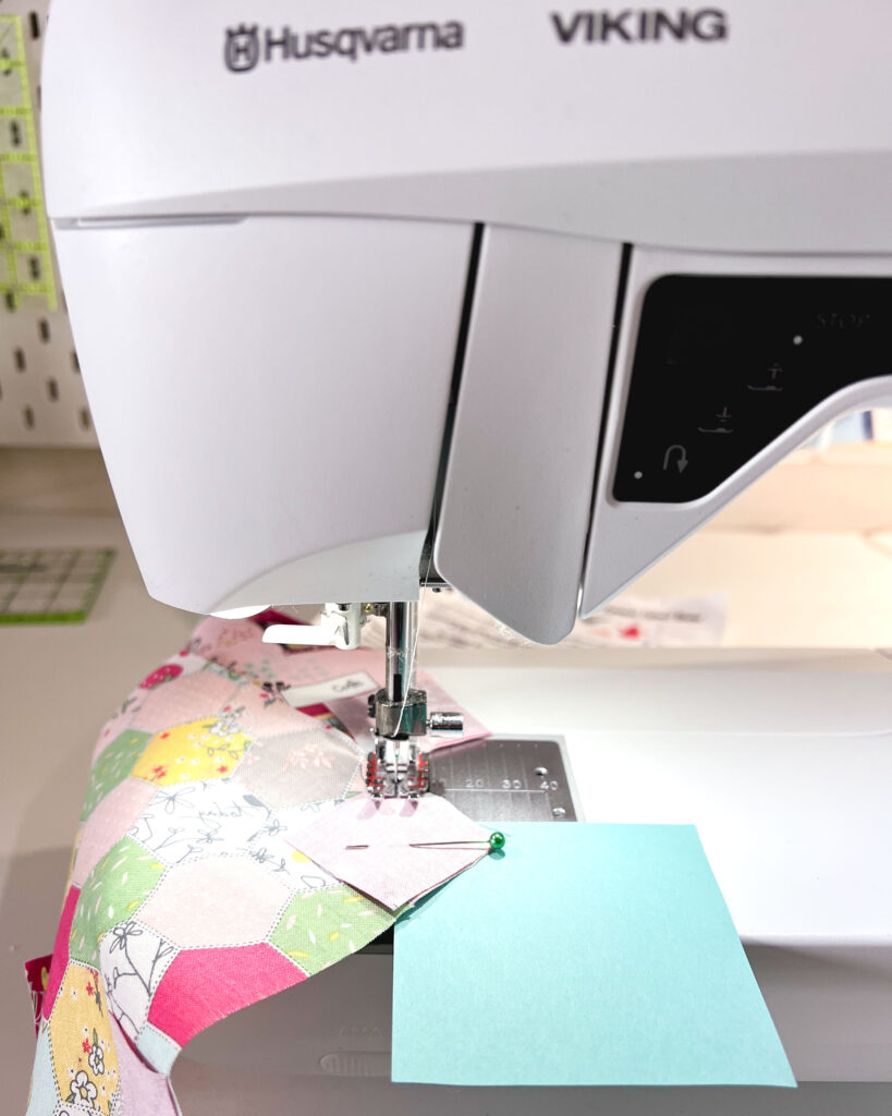 Sew a pretty patchwork pillow with pizzazz with top US sewing blog Ameroonie Designs. Image of sewing accent squares to patchwork pieces.